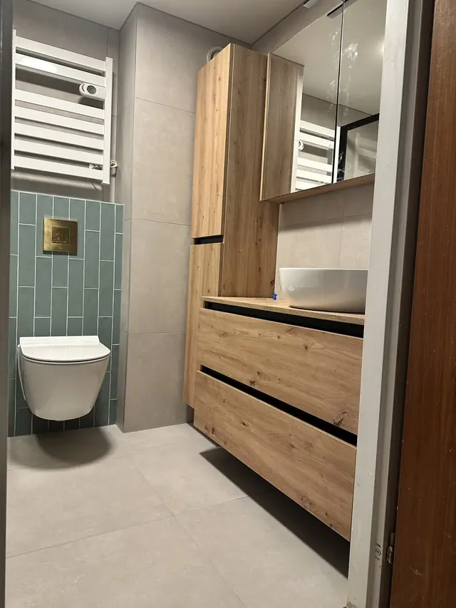 Badkamer met ligbad en groene tegelwand, foto 2 van 7