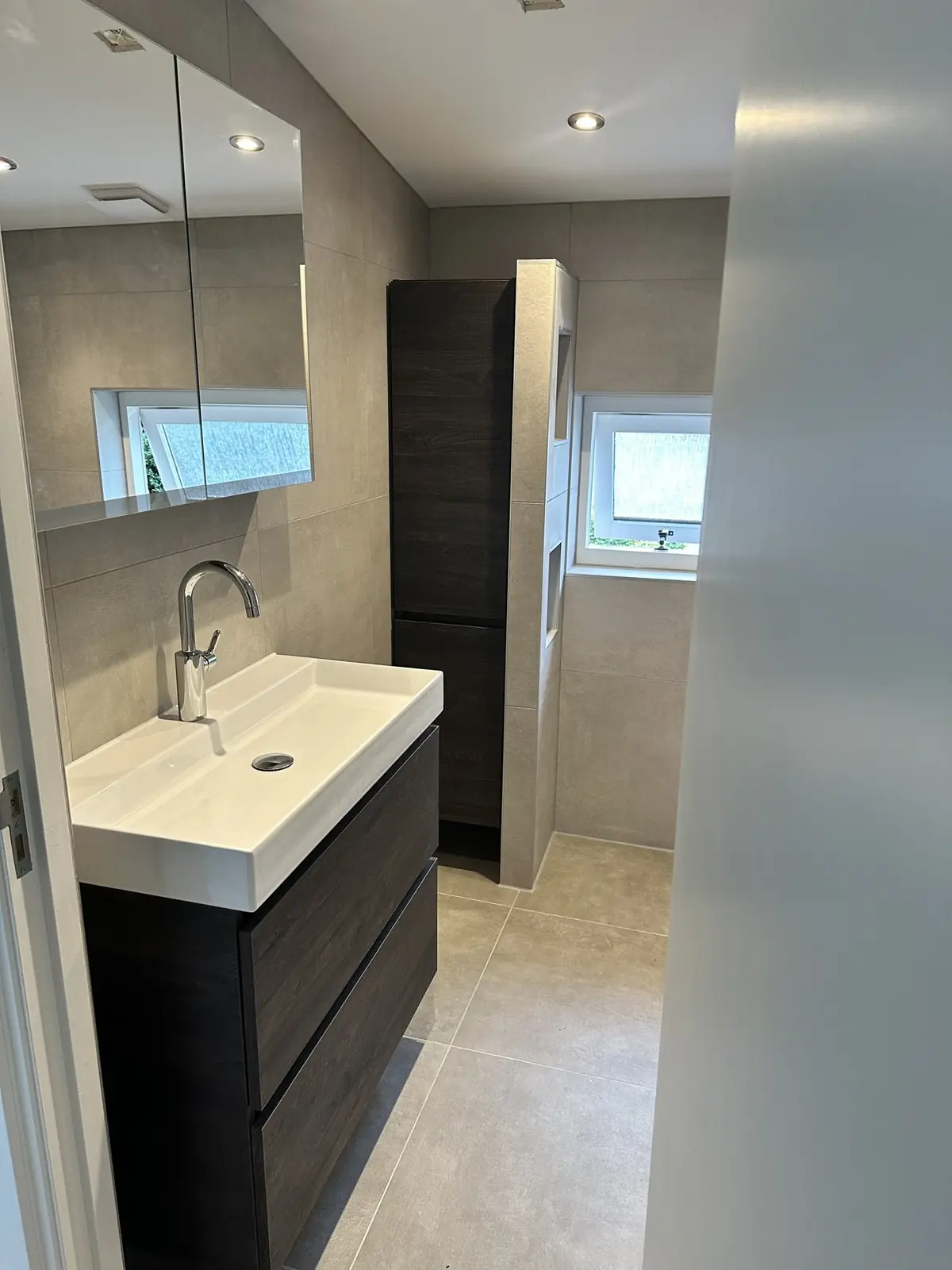 Lichte badkamer met hoge kolomkast in Ede