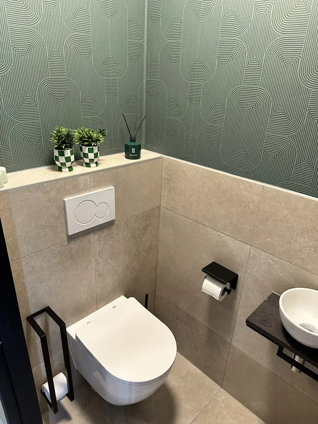 Toilet met groen behang en natuursteentegels, foto 1 van 7